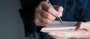 Person writing on a pad