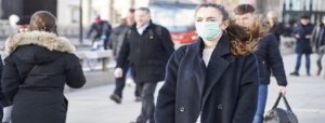 Covid-19, woman walking down street with face mask on