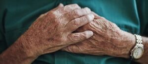 man holding hands over heart, cardiovascular disease, atrial fibrillation, AF, heart failure
