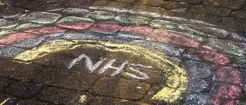 NHS and rainbow written on road with chalk, health and care bill