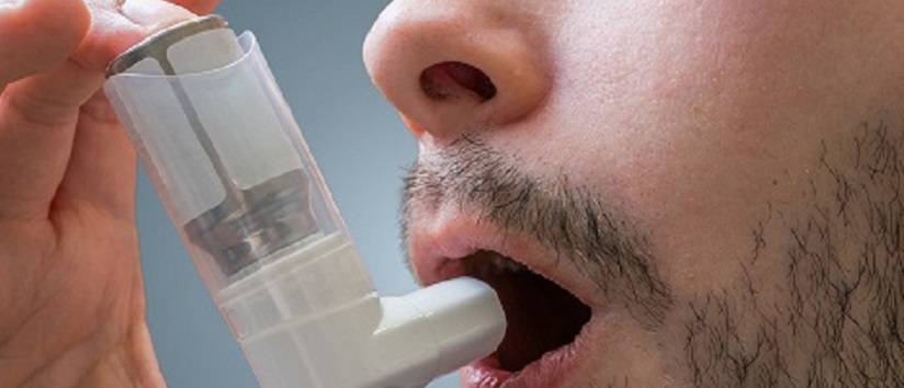 Man with asthma using an inhaler