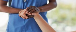Nurse holding the hand of a patient