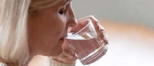 women putting water into mouth