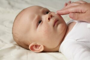 Baby getting cream on skin