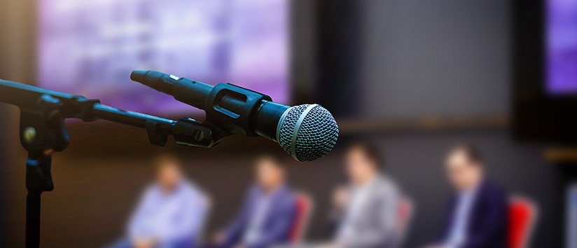 Microphone in front businesspeople blurred in conference