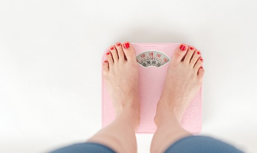 woman stood on scales, eating disorder