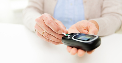 Woman with glucometer checking blood sugar
