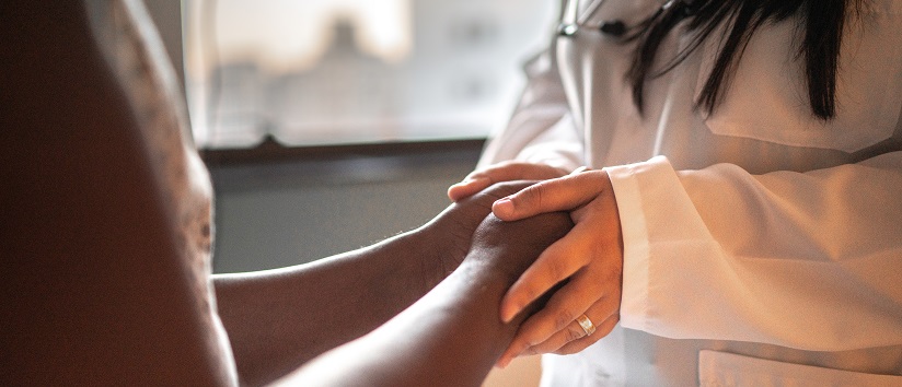 doctor holding patient's hand, women's health