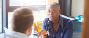 Female GP speaking to patient at desk