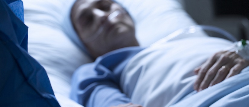Patient lying in hospital bed, end of life care