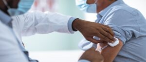 Close up of a mature man taking a vaccine in his doctors office