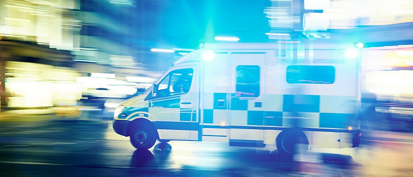 An ambulance driving fast down a street
