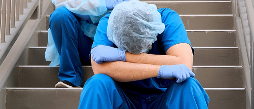 Serious, overworked, healthcare workers wearing protective face masks, NHS crisis