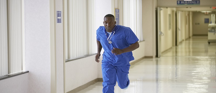 NHS nurse running down a hospital corridor